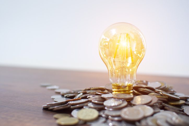 Polk Electric LLC | Light bulb and pile of coins with copy space